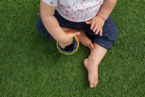 child sitting on artificial grass