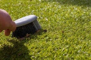 Cleaning your fake grass with a brush